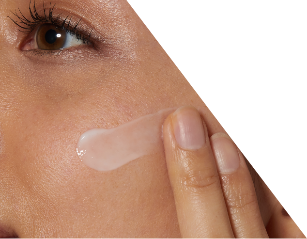 Kobieta rozprowadza niewielką ilość kremu na skórze twarzy