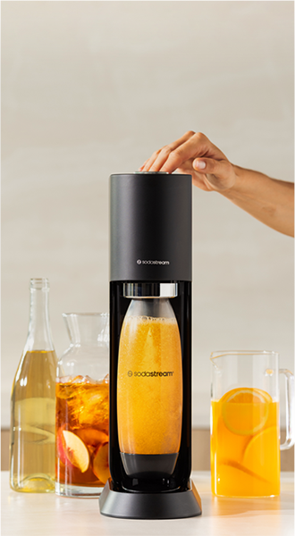 Maszyna do wody gazowanej SodaStream MIX z butelką napoju pomarańczowego w trakcie nasycania