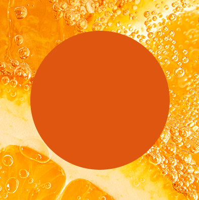 Wlewanie pomarańczowego napoju z dzbanka do butelki Sodastream na blacie