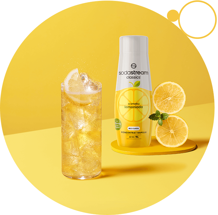 Kobieta w beżowej bluzce obsługująca czarną maszynę Sodastream z różowym napojem w butelce, obok dzbanek i szklanka z lodem